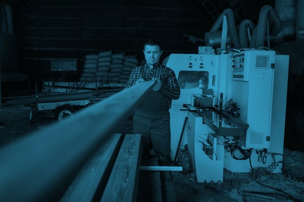 Man putting a plank of wood through a machine