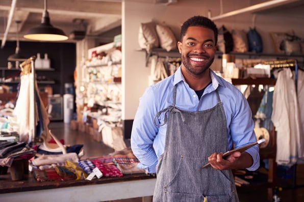 A small business owner holding a tablet while he applies for equipment financing with bad credit at Clicklease 