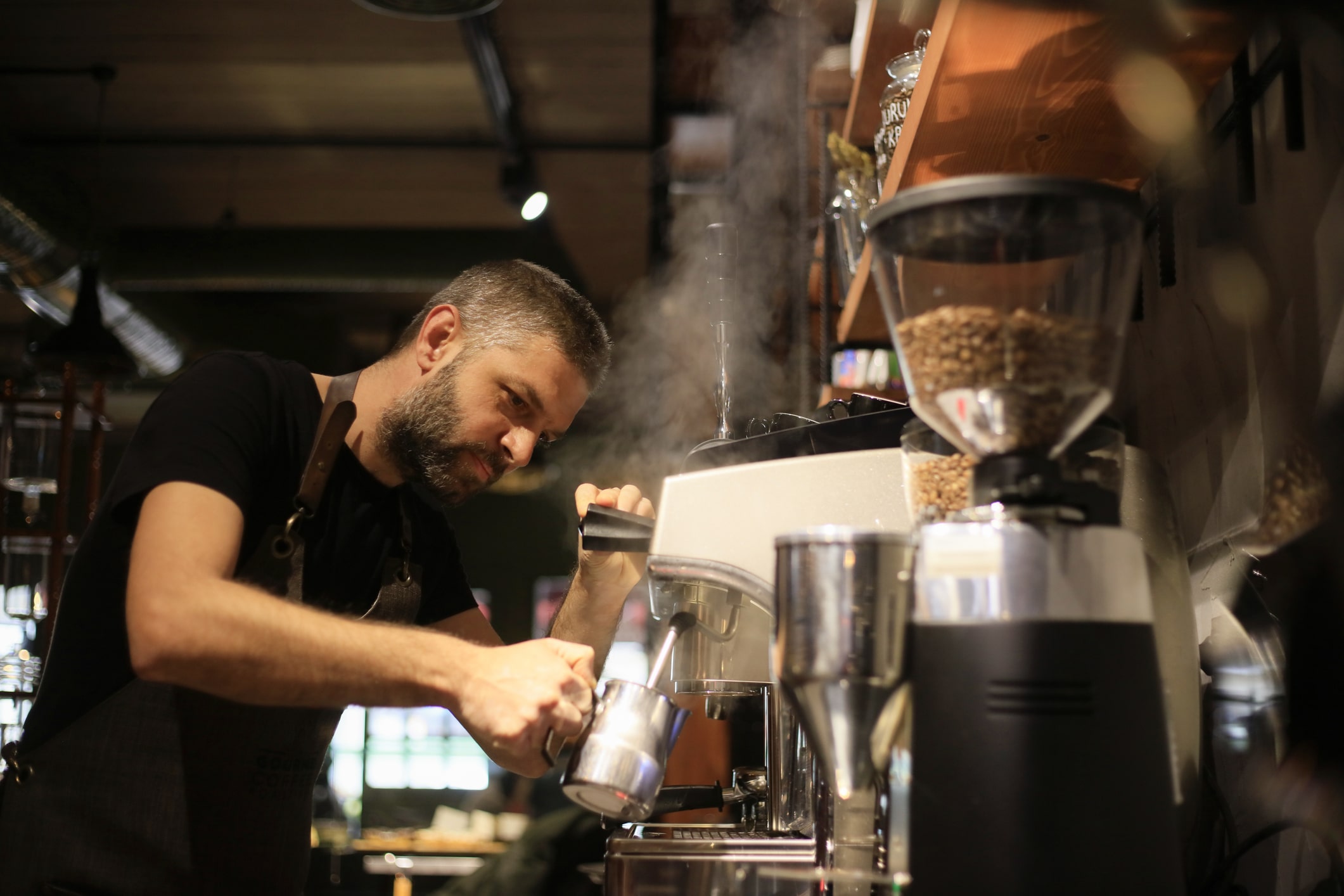 Barista Making Coffee For Customers At Cafe